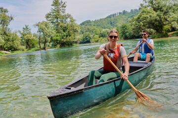 Fototapeta premium friends are canoeing in a wild river