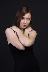 Fototapeta premium Young brown-haired woman, studio photo on a black background