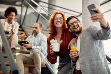 Fototapeta premium Young happy business co-workers taking selfie and enjoying on a break at work.