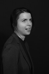 Black and white portrait of a young brunette woman in a studio on a black background