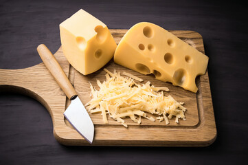 Fresh cheese on a wooden board. On black background.