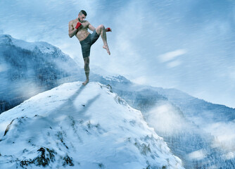 Naklejka na ściany i meble Kickboxer training on mountain top in the winter