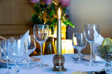 Served table. Plates, glasses, cutlery and candlesticks on a white tablecloth. Decorating the festive table.