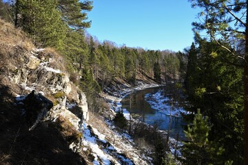 Fototapeta na wymiar picturesque landscape of early spring on the river on a sunny day. Snow melting, nature awakening