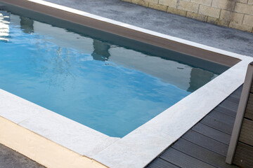 Fototapeta na wymiar Detail of modern outdoor swimming pool in home garden