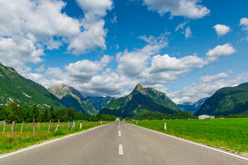 Straight asphalt road through the green pastures