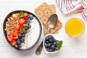 Healthy breakfast with bowl of granola, yogurt and fresh berries