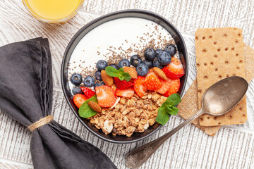 Healthy breakfast with bowl of granola, yogurt and fresh berries