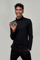 Smiling young african american man holding debit card