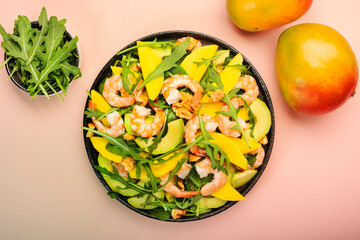 Summer Salad with Mango, Shrimps and Avocado, Walnut, Spinach and Arugula. Healthy Eating food concept Top view, pink background