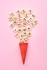 Wooden plaques with numbers and signs in an ice cream cone on a colored background. Study material...