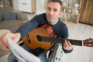 man plays a guitar on a wheelchair