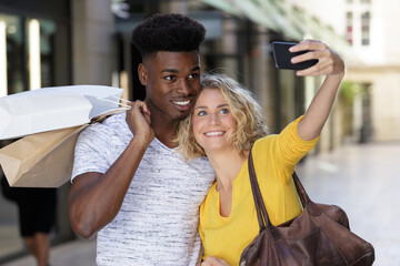 loving mixed couple taking selfie with smartphone together