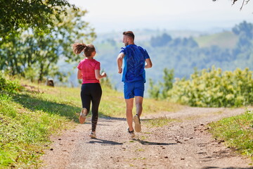 Obraz premium couple enjoying in a healthy lifestyle while jogging on a country road