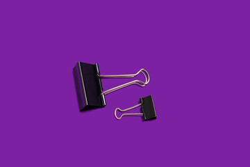 two paper clips on a purple background