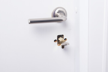 broken white front door lock and handle, close-up