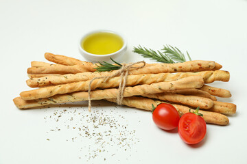 Grissini breadsticks with spices on white background