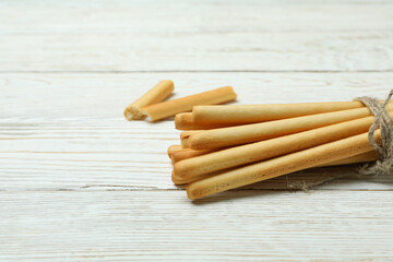 Tasty grissini breadsticks on white wooden background