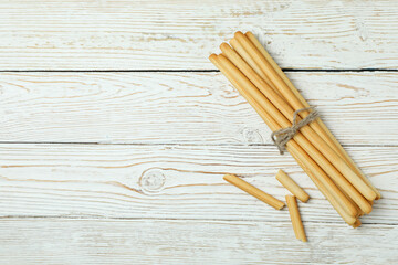 Tasty grissini breadsticks on white wooden background