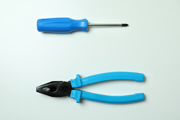 Screwdriver and pliers on white background, space for text