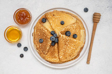 Homemade thin pancakes. Traditional Russian or Ukrainian homemade fried crepes. Light stone background