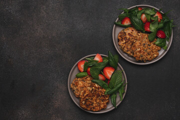 Vegetable fritters and salad with strawberries. Vegetarian lunch. Dark food background