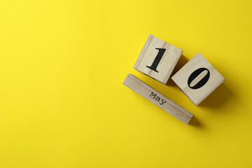 Wooden calendar with 10 may on yellow background