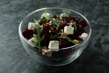 Bowl with fresh beet salad on black smoky background