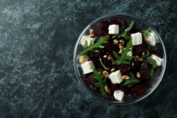 Bowl with fresh beet salad on black smoky background