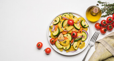 Baked vegetables and meat in plate on white background. Cooked dish of Potatoes, zucchini, carrots, onions, tomato and chicken