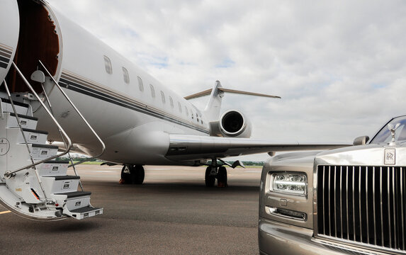 London, UK-7 MAY, 2020: Private executive airplane with limousine Rolls Royce Phantom luxury car shown together at international Heathrow Airport. VIP service at the airport. Business class transfer.