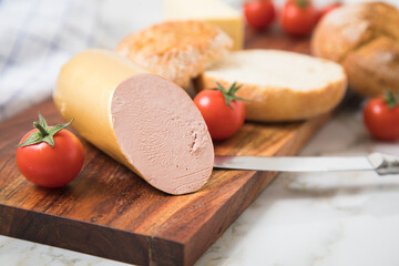 Feine Kalbsleberwurst auf Weizen Rosen Brötchen dazu Tomaten, Butter mit Holzbrett, Geschirrtuch...