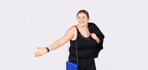 Banner- long format. Plus size business office woman, looking in distance, smile, holding hand, showing something on open palm. Concept of advertisement product, copy space, isolated grey background.