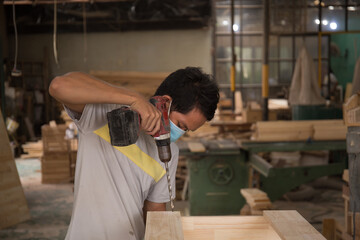 Close-up of carpenter using electric drill in workshop and routing out holes Cabinetmaker drilling...