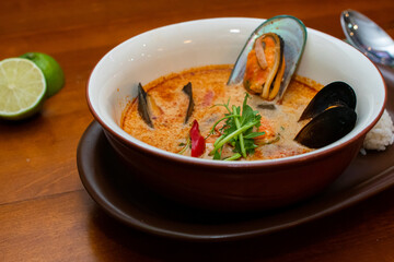 Tom Yam kung Spicy Thai soup with seafood, coconut milk and chili pepper 