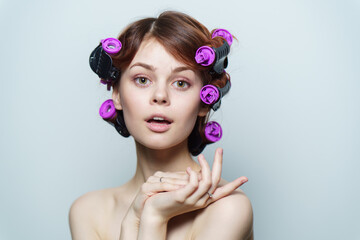 wind curls of hair purple curlers on the head of a red-haired woman