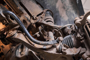 Inspects suspension, steering parts, tie rod ends. Car on a repair stand. Technical service station for car.