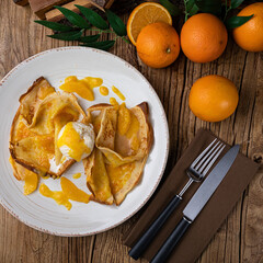 Pancakes with orange jam and ice cream on a large white plate
