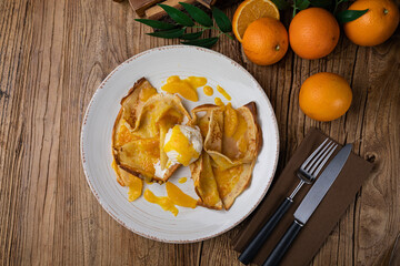 Pancakes with orange jam and ice cream on a large white plate
