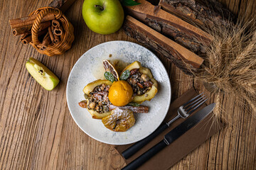 Dessert with baked apple, cinnamon, raisins and ice cream
