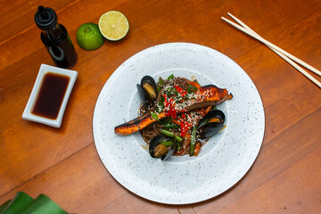 Traditional asian noodles with salmon and mussels