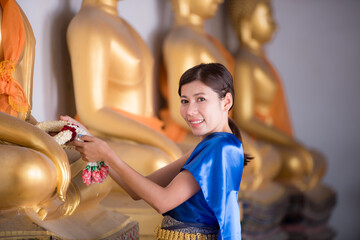 The girl in Thai dress presents a garland for the Lord Buddha.preserving the good culture of Thai people during Songkran festival. Thai New Year, Family Day in April