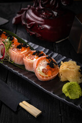 Japanese rolls on a dark plate in a restaurant
