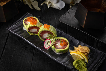 Japanese rolls on a dark plate in a restaurant
