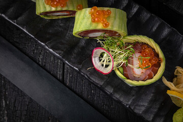 Japanese rolls on a dark plate in a restaurant
