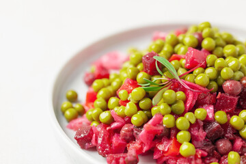 Salad vinaigrette with beets and vegetables on a plate on the table. Healthy diet