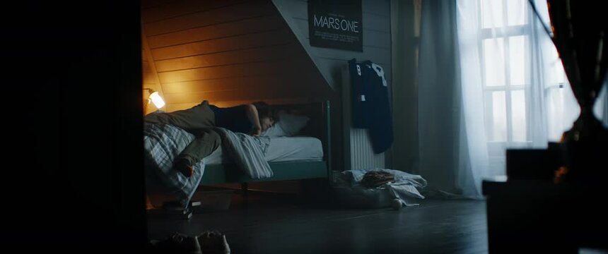 WIDE bored little Caucasian kid entring his bedroom, playing baseball catch with himself at home. Shot with 2x anamorphic lens