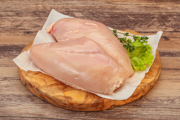 Raw chicken breast over board