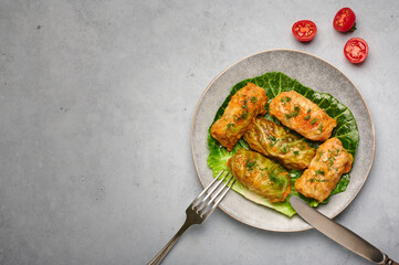Golubtsi or golabki on gray plate on concrete table top. Stuffed cabbage rolls dish of russian, polish, ukrainian cuisine. European food.