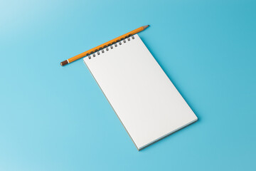 White notebook,pencil, on blue background. top view copy space